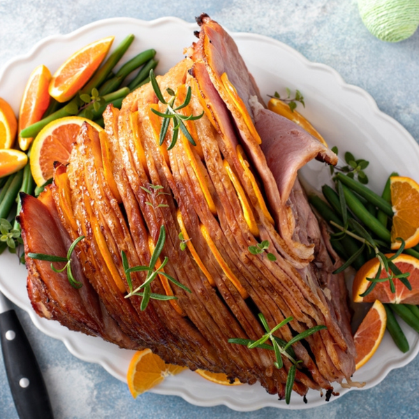 Glazed Spiral Ham with Oranges and Green Beans on a white platter