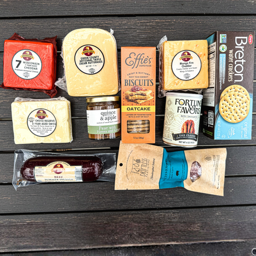 Assorted food items including cheese, biscuits, and crackers on a wooden surface