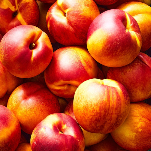 Close-up of a pile of ripe nectarines with a vibrant color.