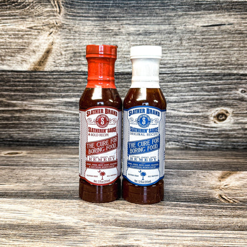 2 bottles of slathering sauce on a wooden table